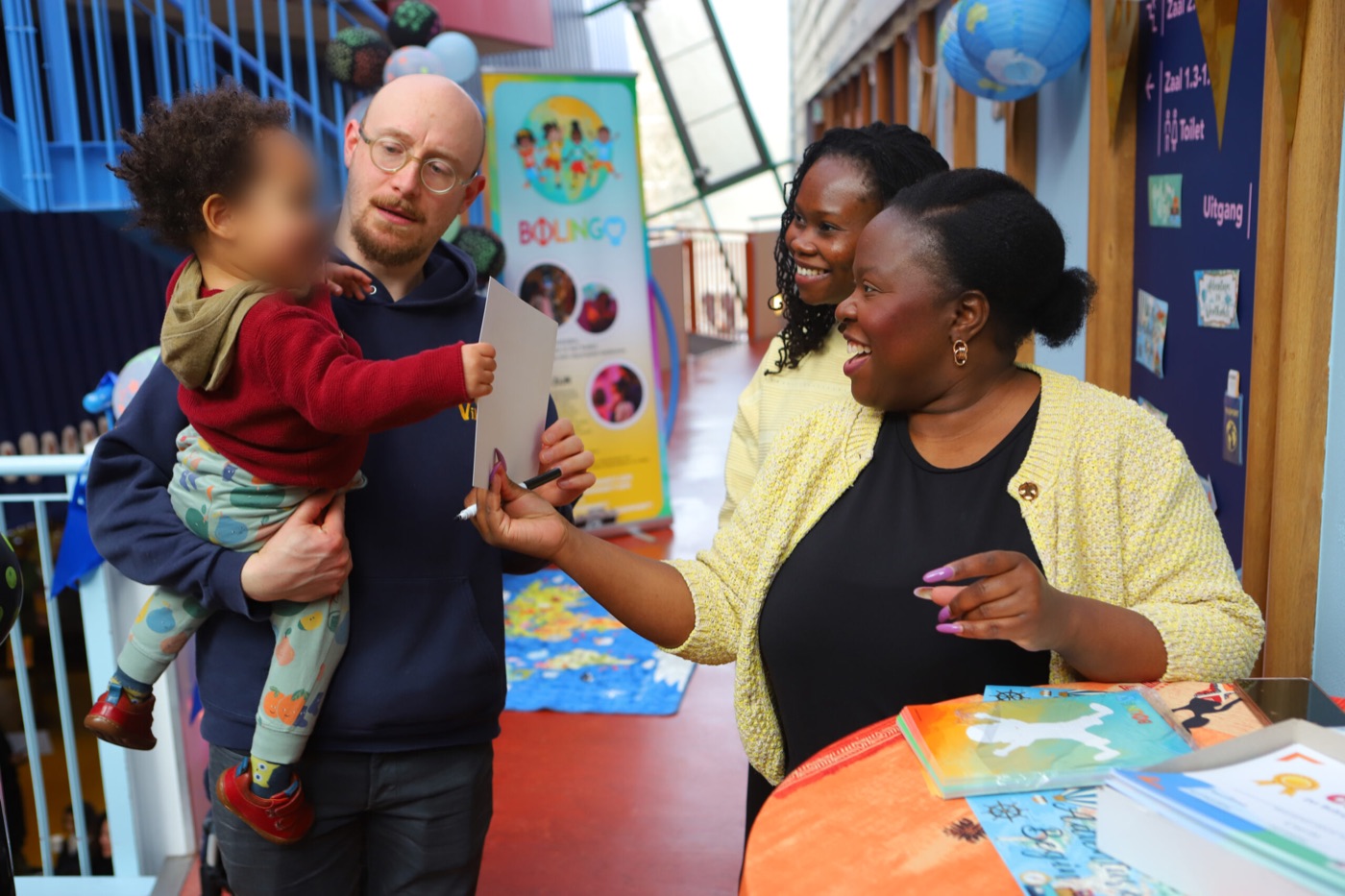 Carla signeert een kinderboek op het Bolingo Kids x iAfrica Kinderfilmfestival